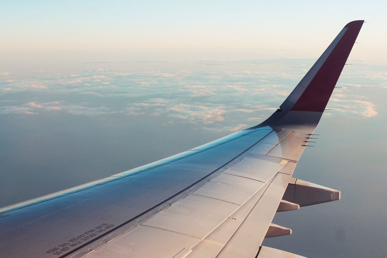Mastering the First Impression: Your intriguing post title goes here A breathtaking view from an airplane window showcasing clouds and a wing tip over a serene sky.